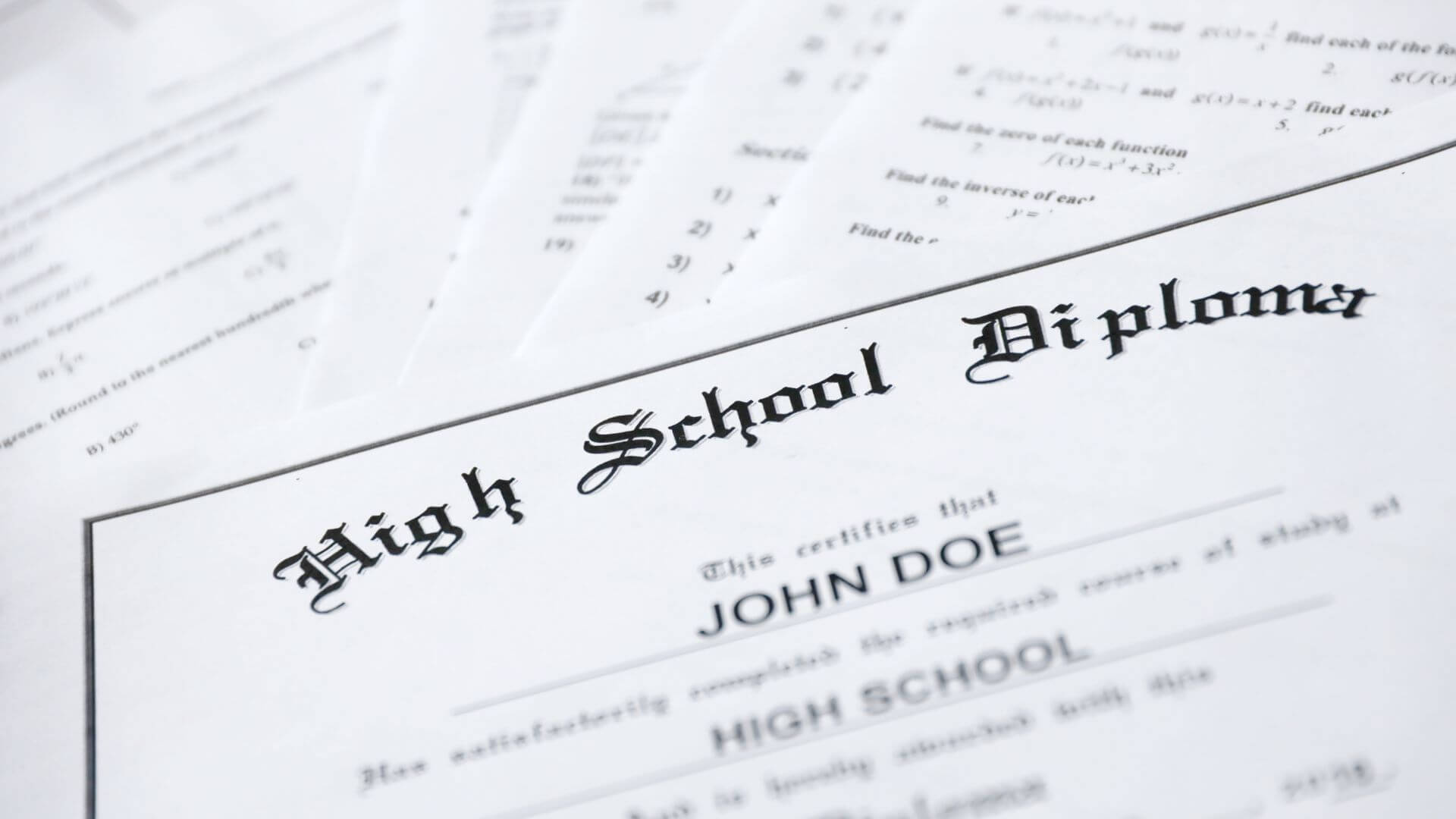 a stack of high school paper documents including high school diplomas, transcripts, certifications, and more.